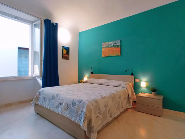 Camera familiare con letto matrimoniale e parete verde ad Ascoli Piceno